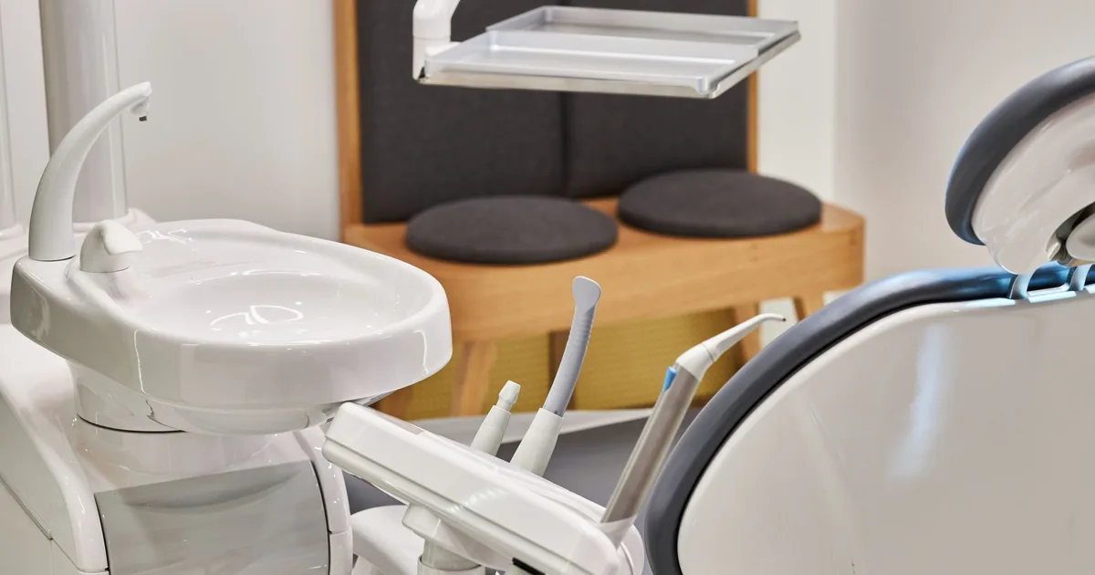 Fauteuil et équipement de cabinet dentaire vides, plateau technique en arrière-plan