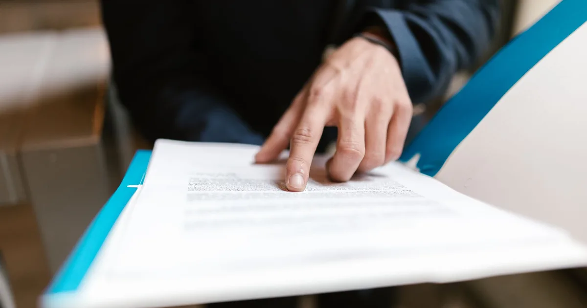Dirigeant d'entreprise consultant ses documents de couverture sociale pour évaluer une assurance chômage privée