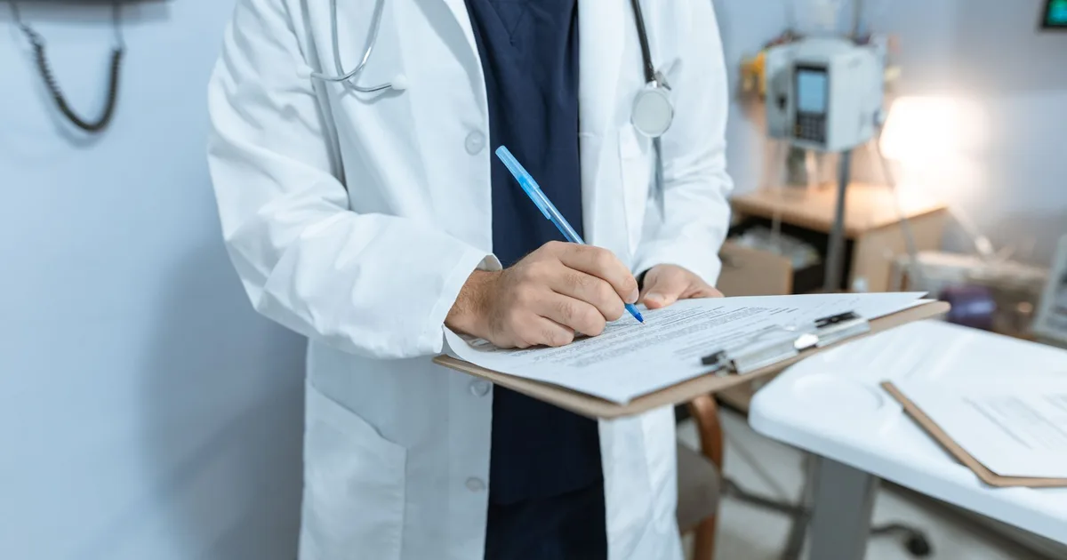 Stéthoscope posé sur un bureau de cabinet médical à côté de documents d'assurance