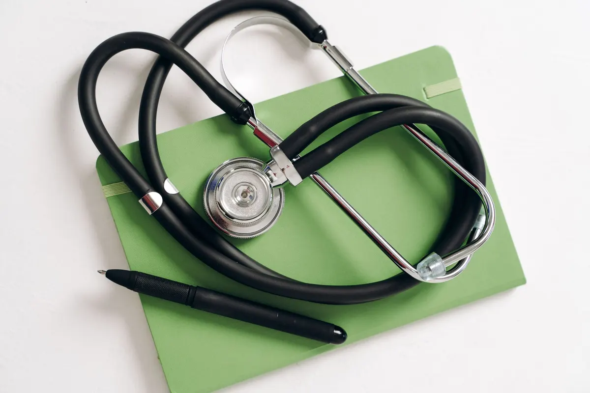 Stéthoscope posé à côté d'un arrêt de travail vierge sur un bureau