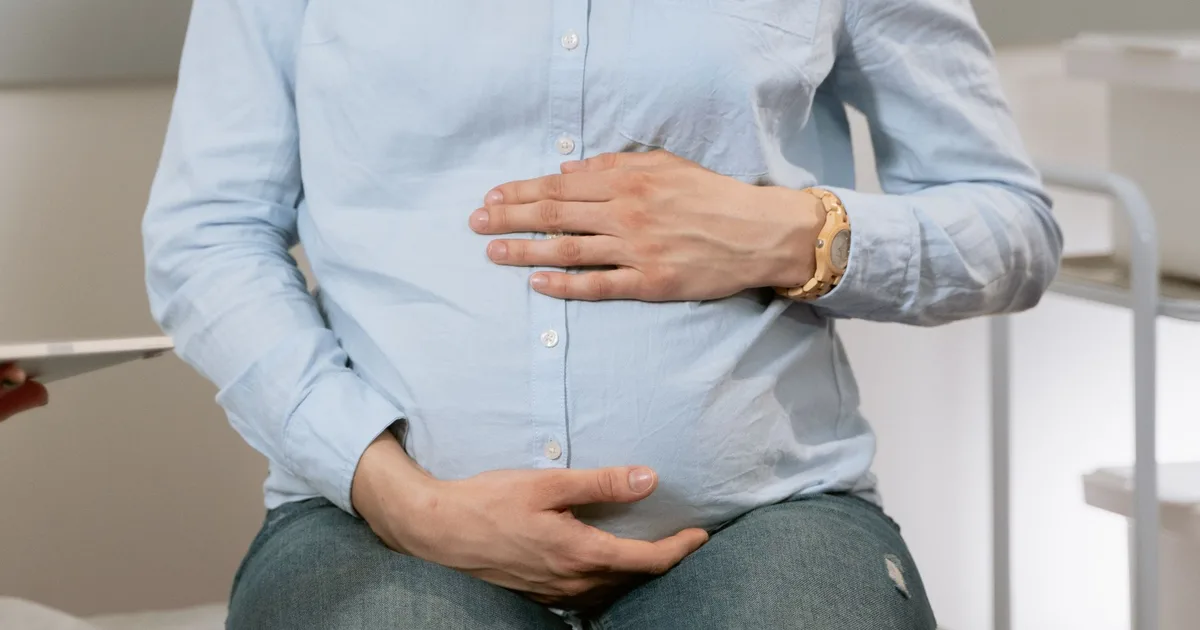 Sage-femme enceinte en consultation, question du congé maternité en libéral