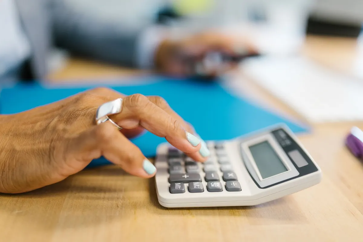 Documents de comparaison de contrats de mutuelle posés sur un bureau avec une calculatrice