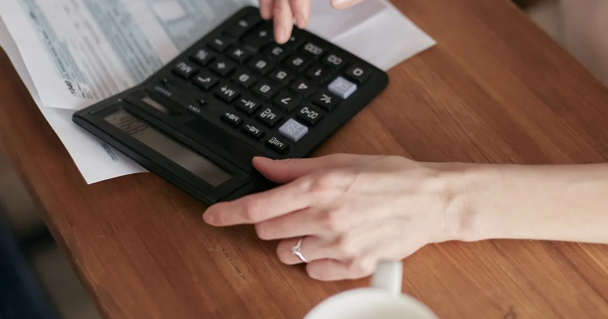 Expert-comptable libéral au bureau, calculatrice et dossiers de bilan