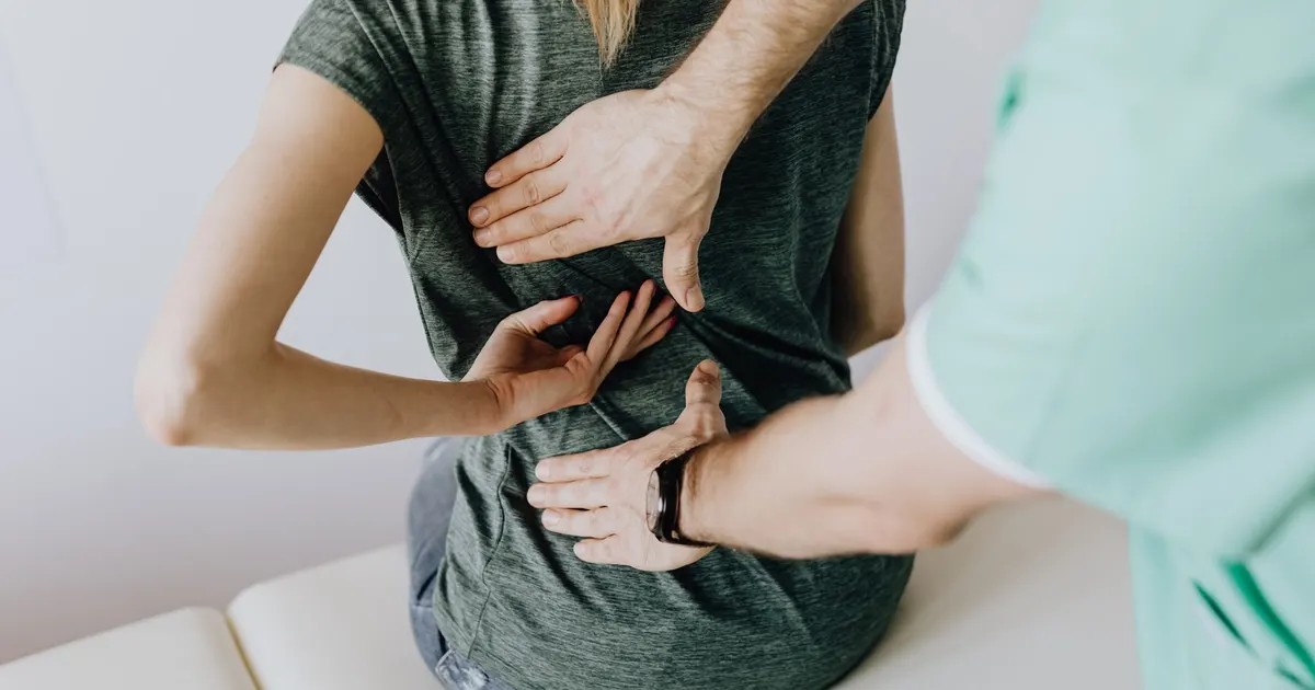 Ostéopathe manipulant l'épaule d'un patient sur une table de consultation
