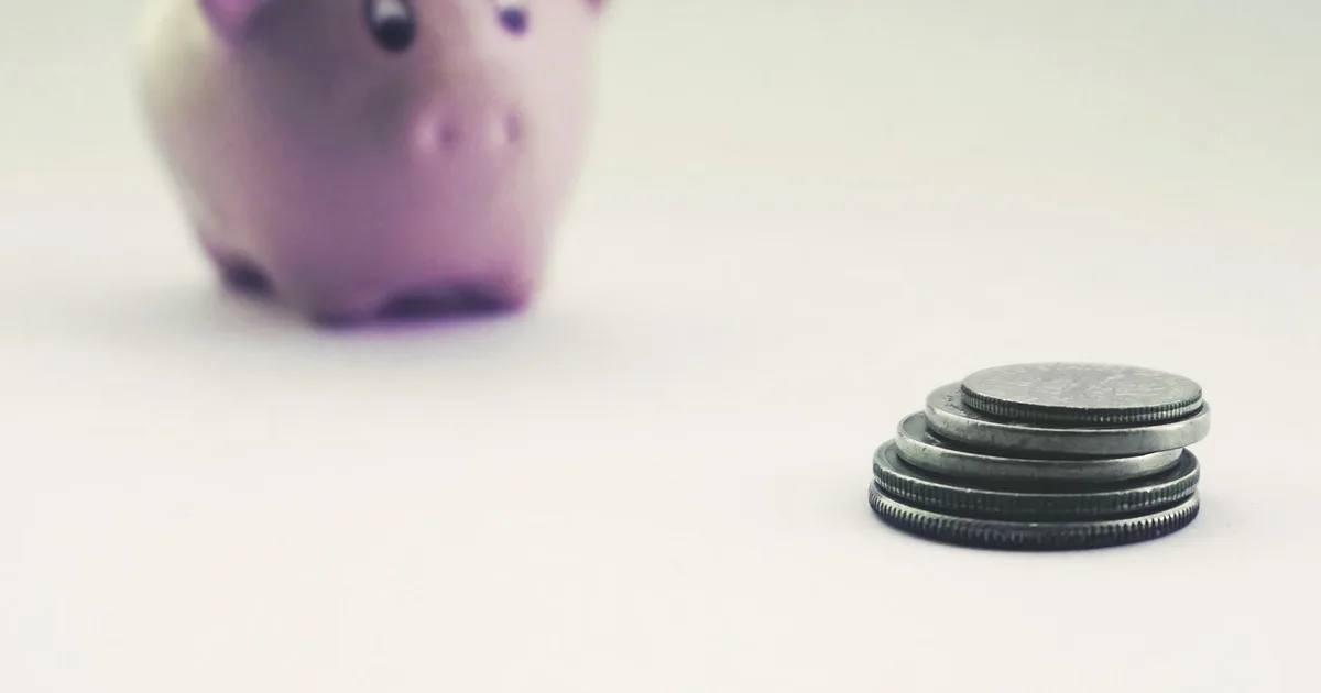 Jeune indépendant calculant son budget prévoyance sur un carnet avec une calculatrice