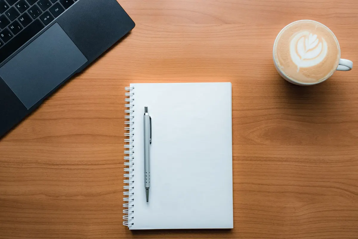 Carnet de rendez-vous vierge et stylo sur un bureau de psychologue en arrêt de travail