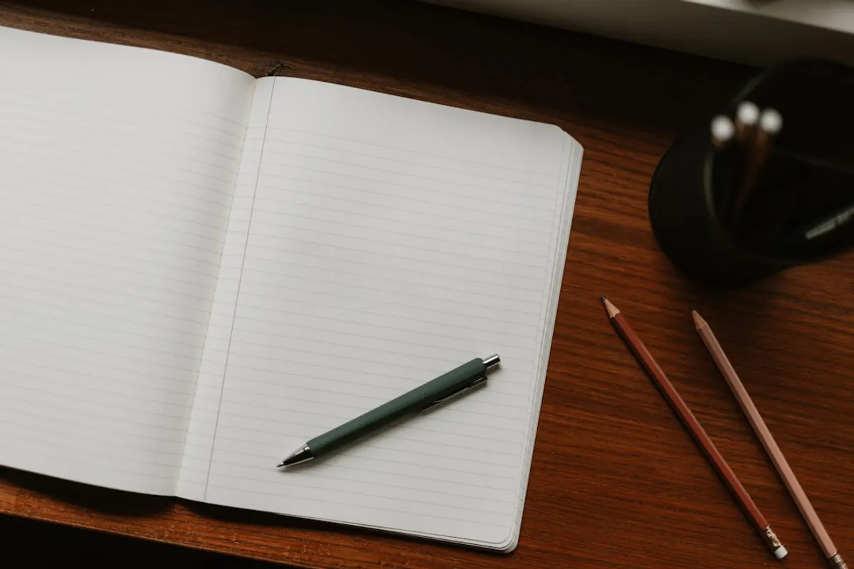 Carnet vierge et stylo sur un bureau en bois, symbole du contrat de remplacement à signer